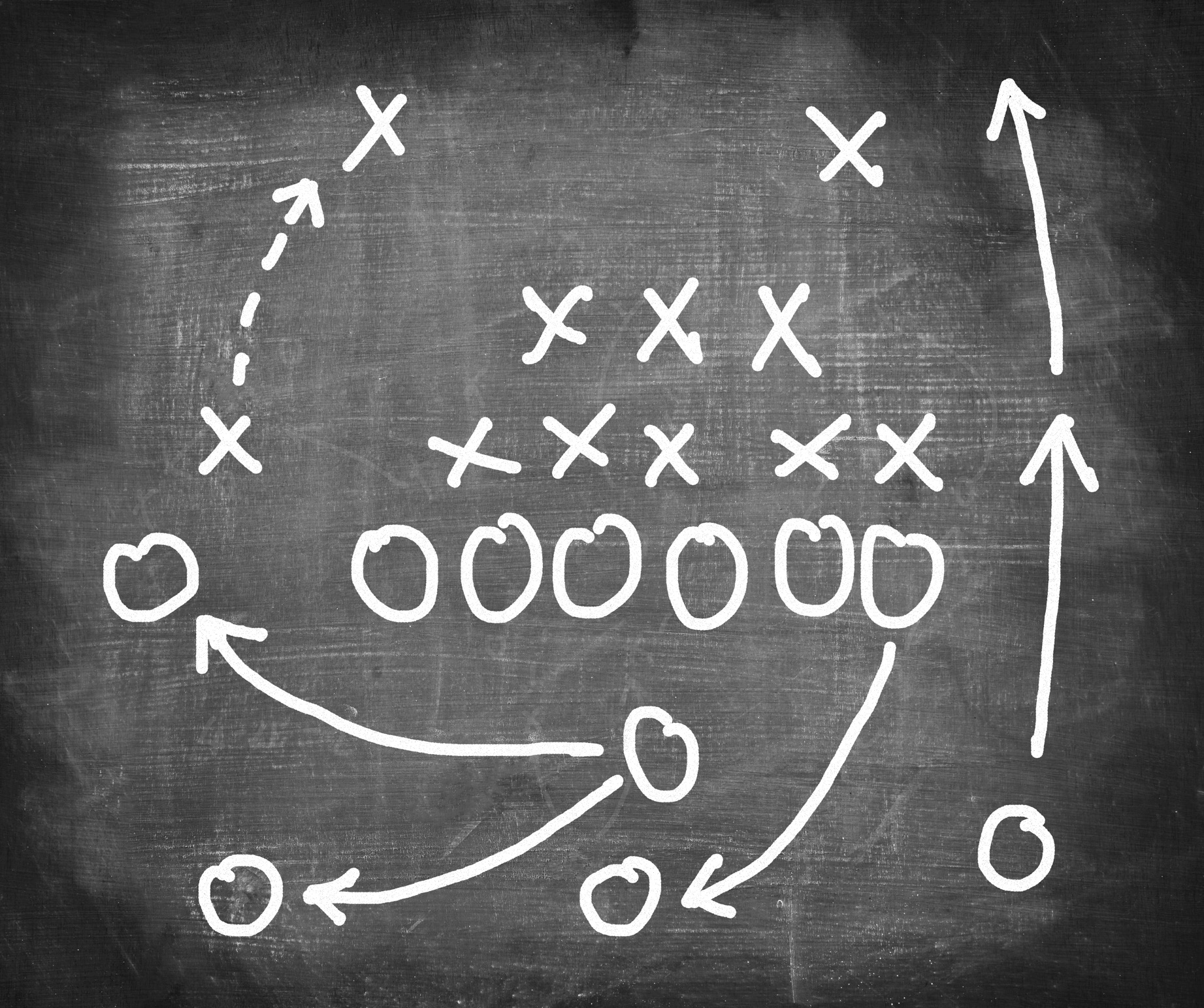 Football strategy laid out on chalk board with X's and O's