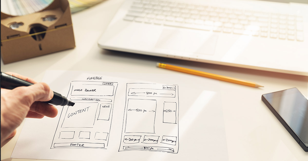 Person drawing a homepage wireframe and an interior page wireframe